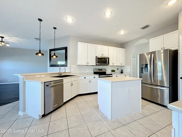 a kitchen with stainless steel appliances white cabinets and refrigerator