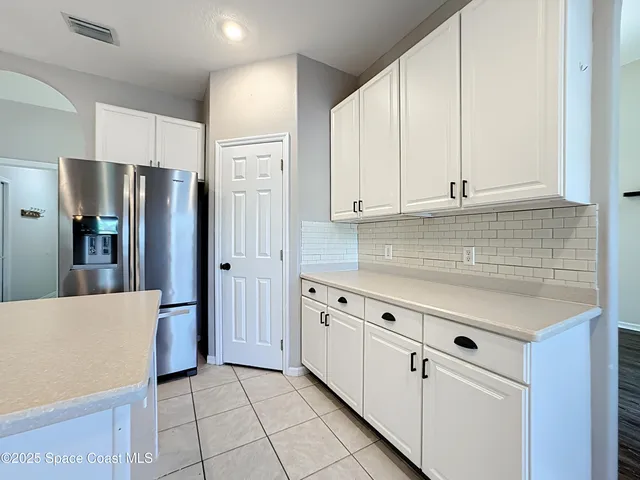 a kitchen with white cabinets and appliances
