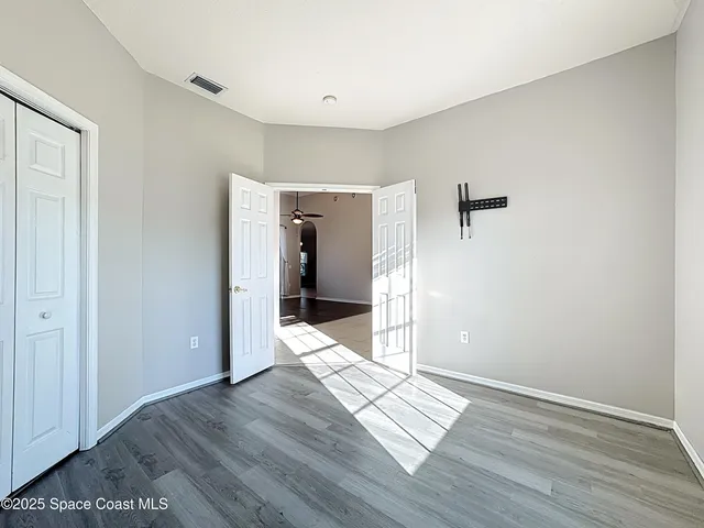 a spacious bathroom with a granite countertop sink a toilet a mirror and shower