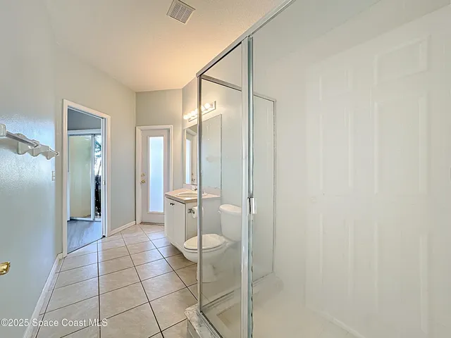 a view of empty room with wooden floor and ceiling fan