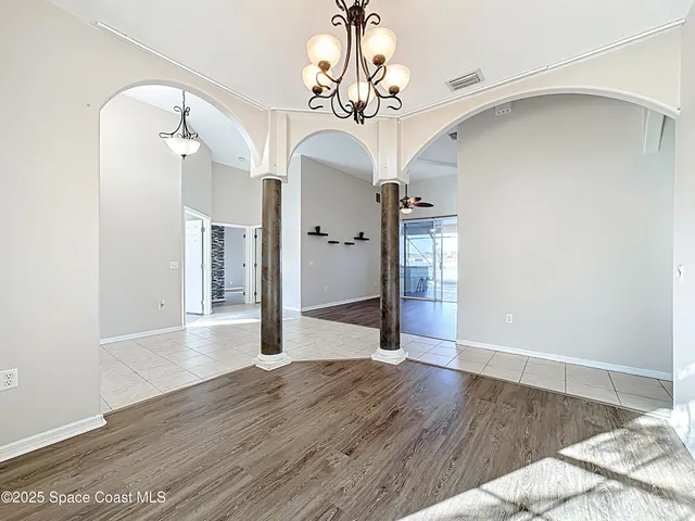 a view of a hallway with wooden floor and a chandelier