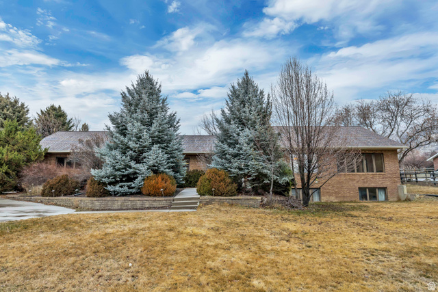 View of front of property with brick siding and a front lawn