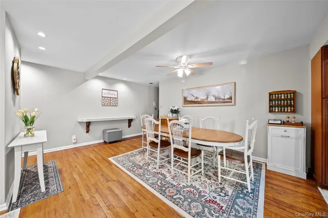 a dining room with wooden floor and a chandelier