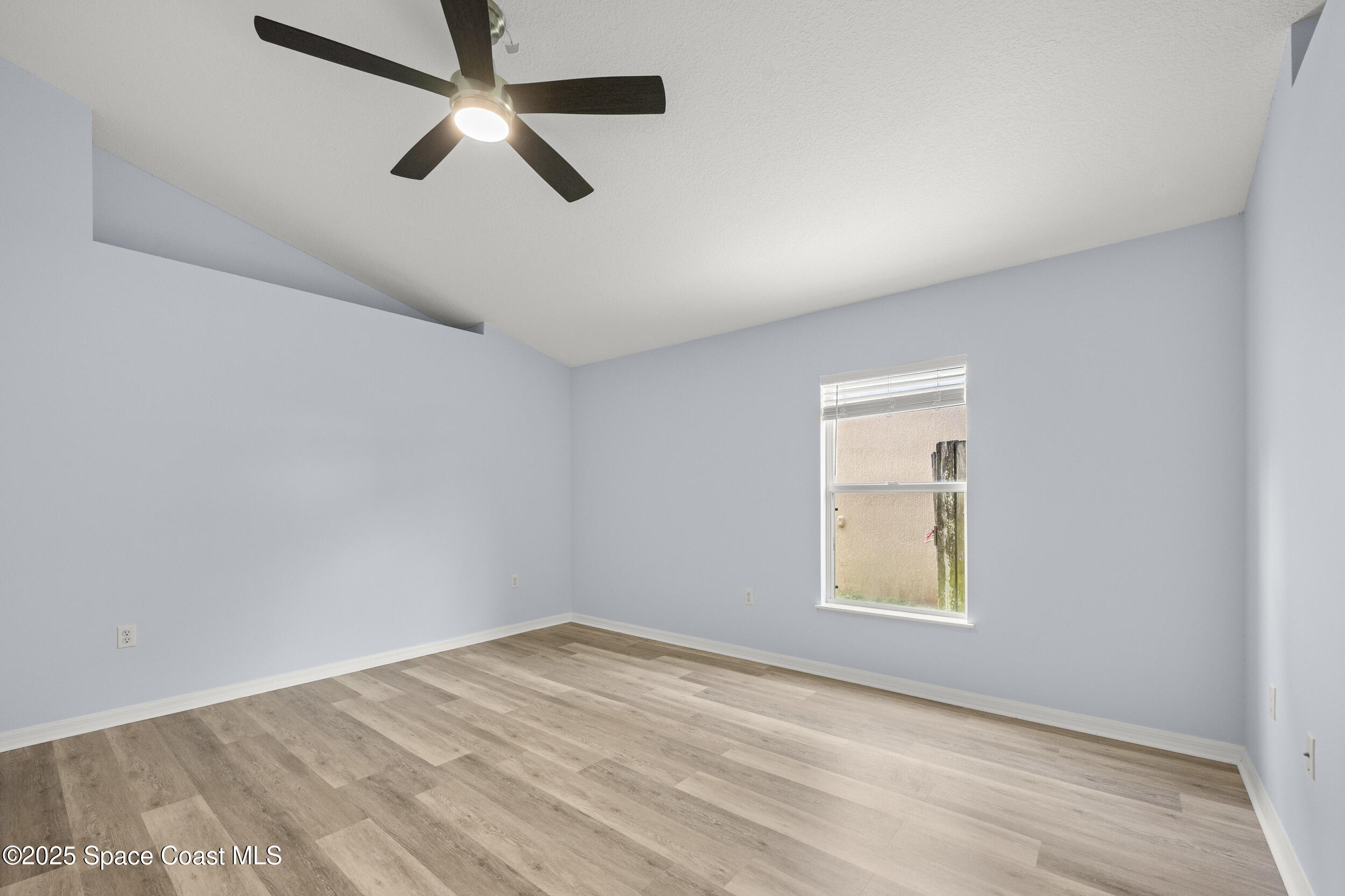 2100 Canopy Drive Melbourne, FL 32935 - Photo 4 of 53 an empty room with a window and a fan