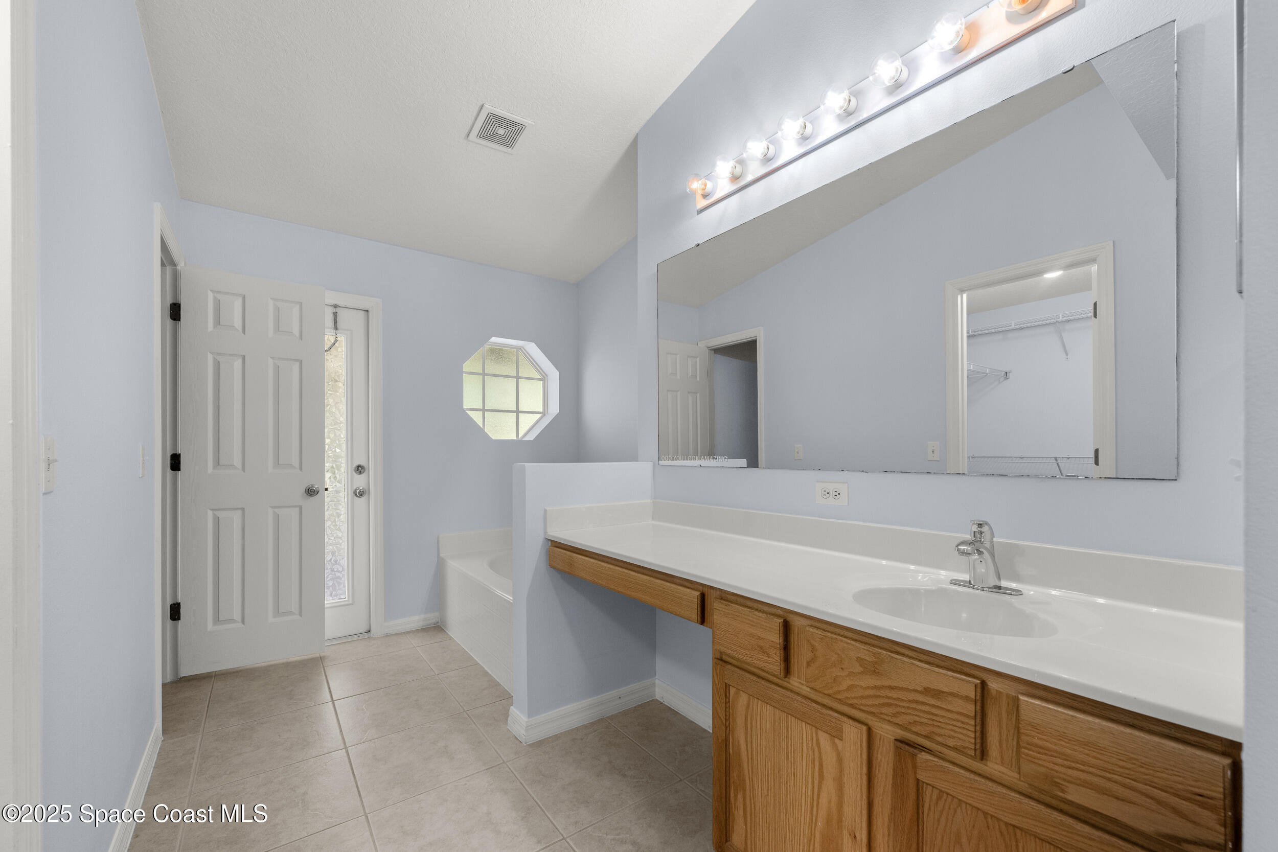 2100 Canopy Drive Melbourne, FL 32935 - Photo 8 of 53 a bathroom with a sink a light fixture and a mirror