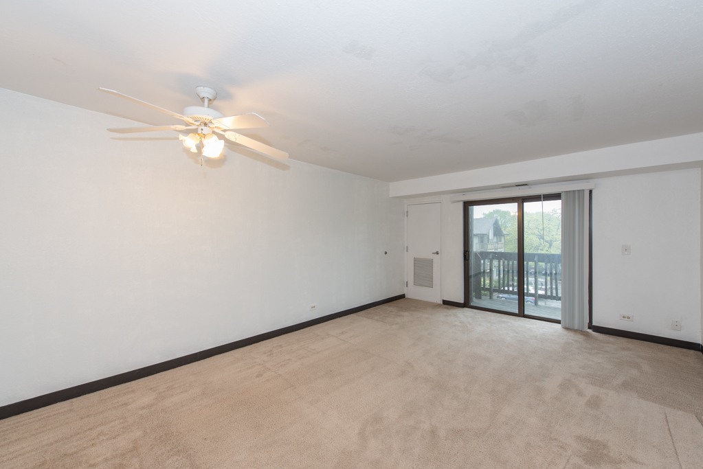 2640 North Delany Road, Unit 202 Waukegan, IL 60087 - Photo 4 of 22 an empty room with chandelier fan and windows