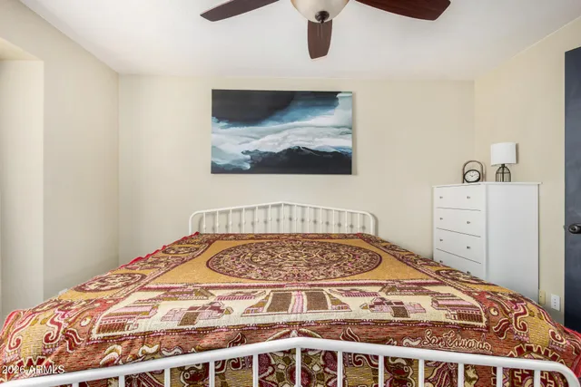 a bedroom with a bed and painting on the wall