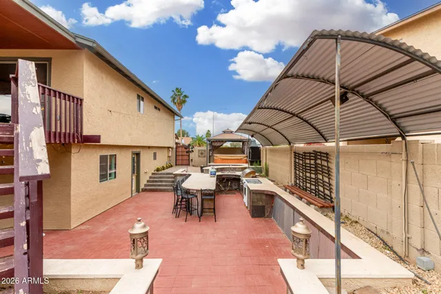 a view of a patio with table and chairs with wooden floor and fence