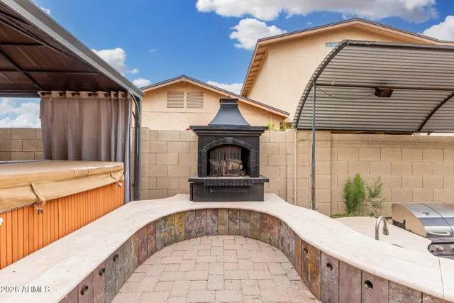 a front view of a house with barbeque oven and seating space