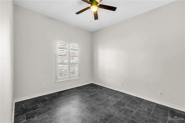 an empty room with window and a ceiling fan