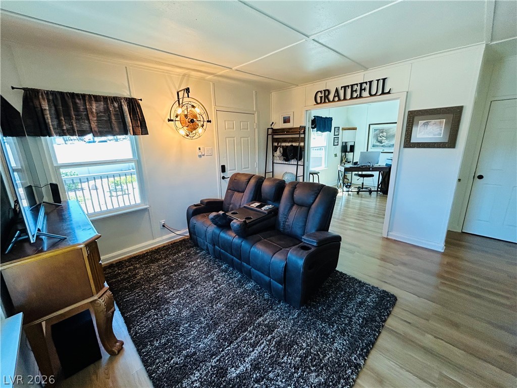 116 West Basic Road Henderson, NV 89015 - Photo 18 of 39 Natural light filters through the window, illuminating warm hardwood flooring in this cozy living space.