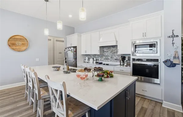 a large kitchen with stainless steel appliances lots of counter space and a sink