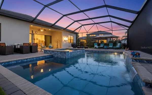 an aerial view of a house with a yard swimming pool and outdoor seating