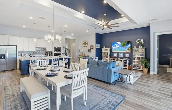 a view of a dining room with furniture a chandelier and large window