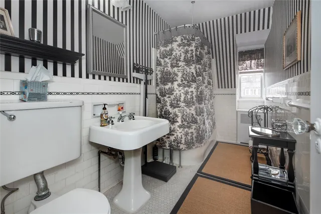 a bathroom with a sink a toilet and a mirror