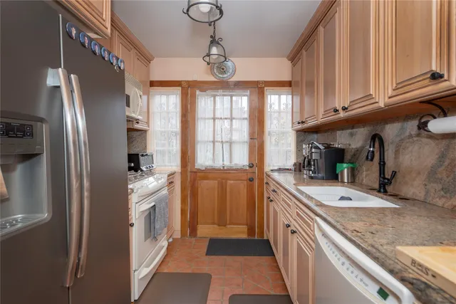 a kitchen with stainless steel appliances granite countertop a refrigerator and a sink