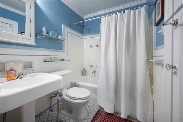 a bathroom with a sink a toilet and shower curtain