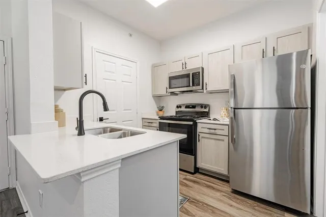 a kitchen with stainless steel appliances white cabinets and a stove top oven