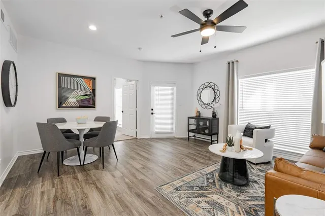 a living room with furniture a table and wooden floor