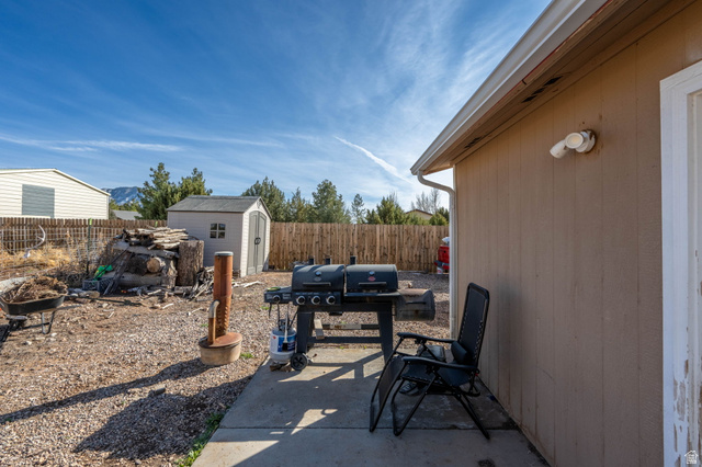 348 North Lodge Road Central, UT 84722 - Photo 13 of 25 Fenced backyard featuring a storage shed, a patio, and a grill