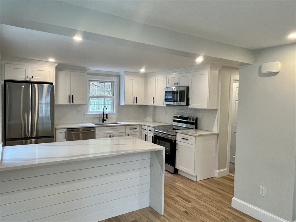 69 Brookside Road Braintree, MA 02184 - Photo 5 of 28 a kitchen with stainless steel appliances granite countertop a stove a sink and a refrigerator