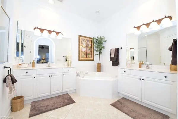 a spacious bathroom with a sink a mirror a vanity and bathtub