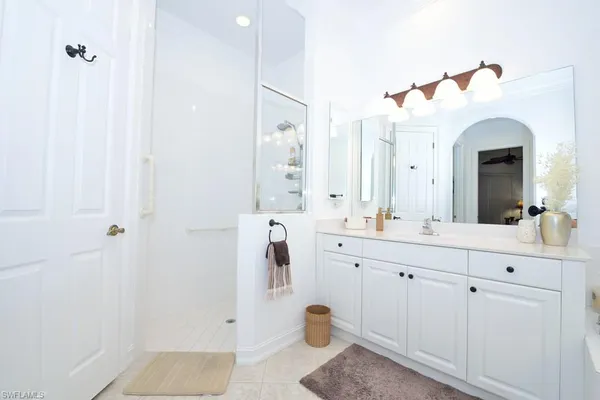 a bathroom with a double vanity sink mirror and shower