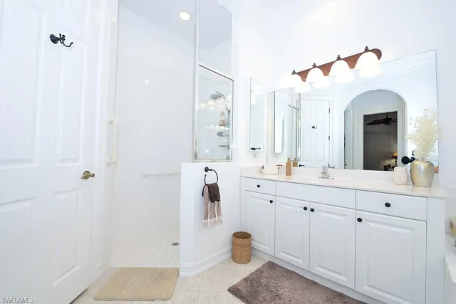 a bathroom with a double vanity sink mirror and shower
