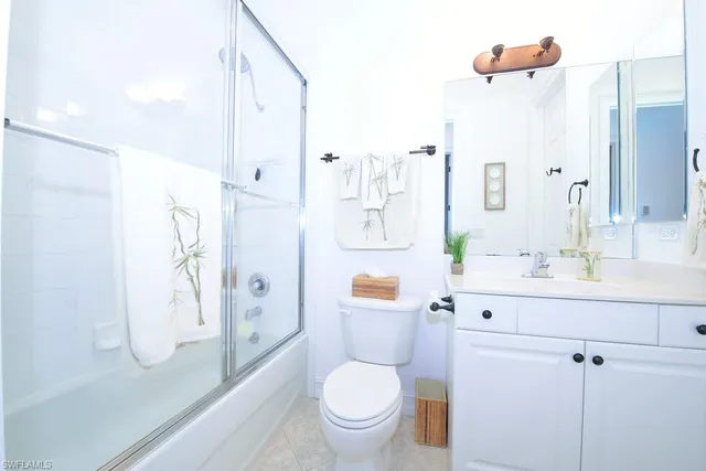 a bathroom with a granite countertop sink a toilet and shower