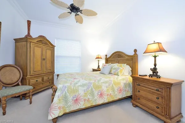 a bedroom with a bed a dresser and chair