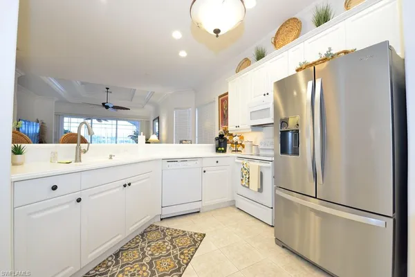 a kitchen with white cabinets and white appliances