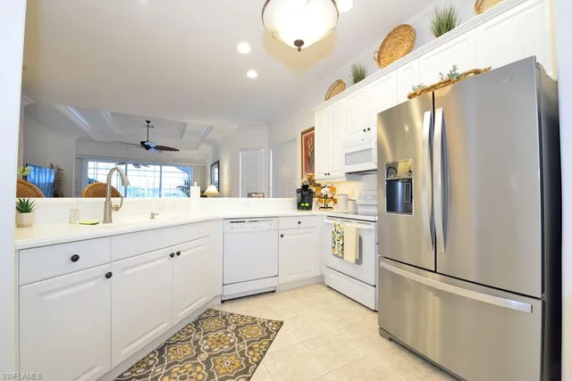 a kitchen with white cabinets and white appliances