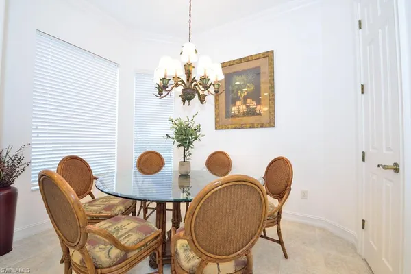 a dining room with chandelier and wooden floor