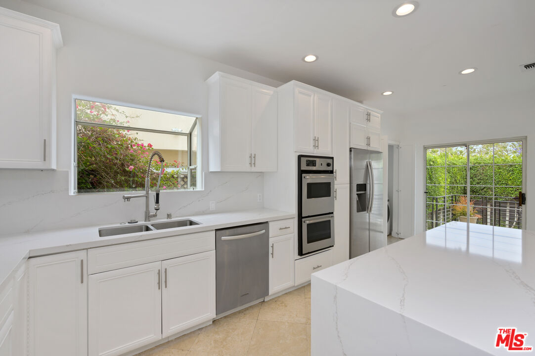 a kitchen with a sink a window and stainless steel appliances