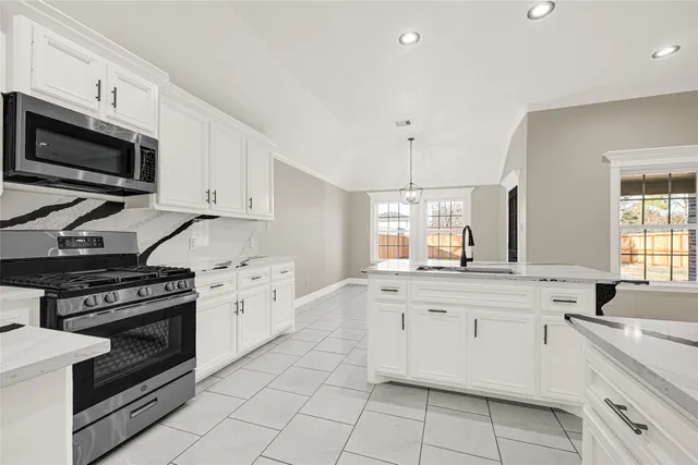 a kitchen with a stove top oven sink and cabinets