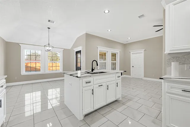 a kitchen with granite countertop a sink and cabinets