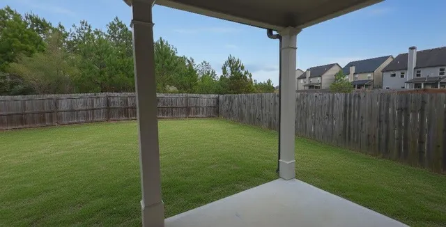 a view of a backyard with a small yard and wooden fence