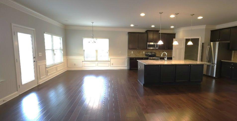 4191 Towncastle Lane Buford, GA 30518 - Photo 6 of 21 a open kitchen with stainless steel appliances granite countertop a sink dishwasher a stove and a large window with wooden floor