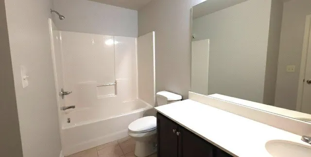 a bathroom with a sink toilet vanity and shower