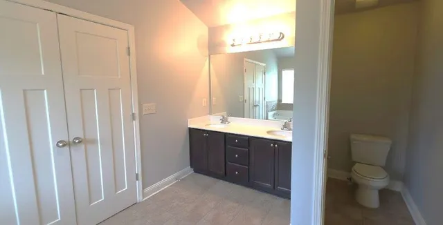 a bathroom with a sink vanity mirror and toilet