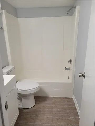 a white toilet sitting next to a bath tub