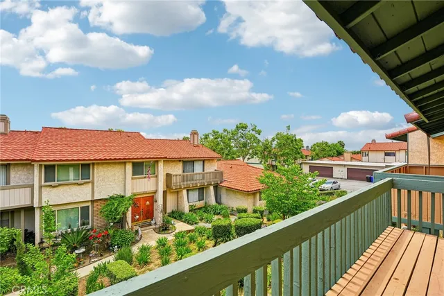 a view of a balcony with wooden floor & fence