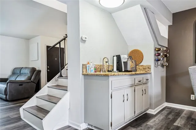 a hallway with a couch and dresser with wooden floor