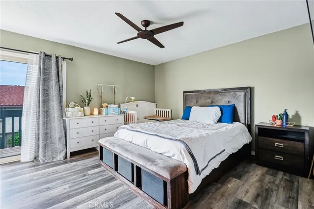 a bedroom with a bed a large window and mirror