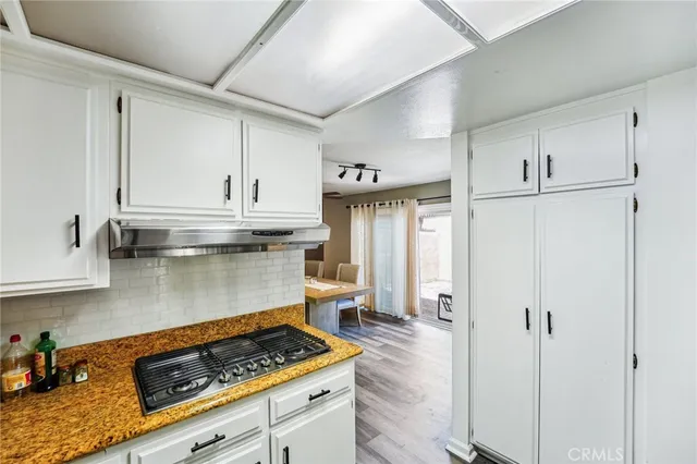 a kitchen with white cabinets and appliances