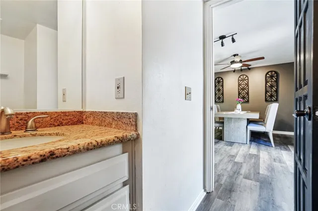 a en suite bathroom with a granite countertop sink and a mirror