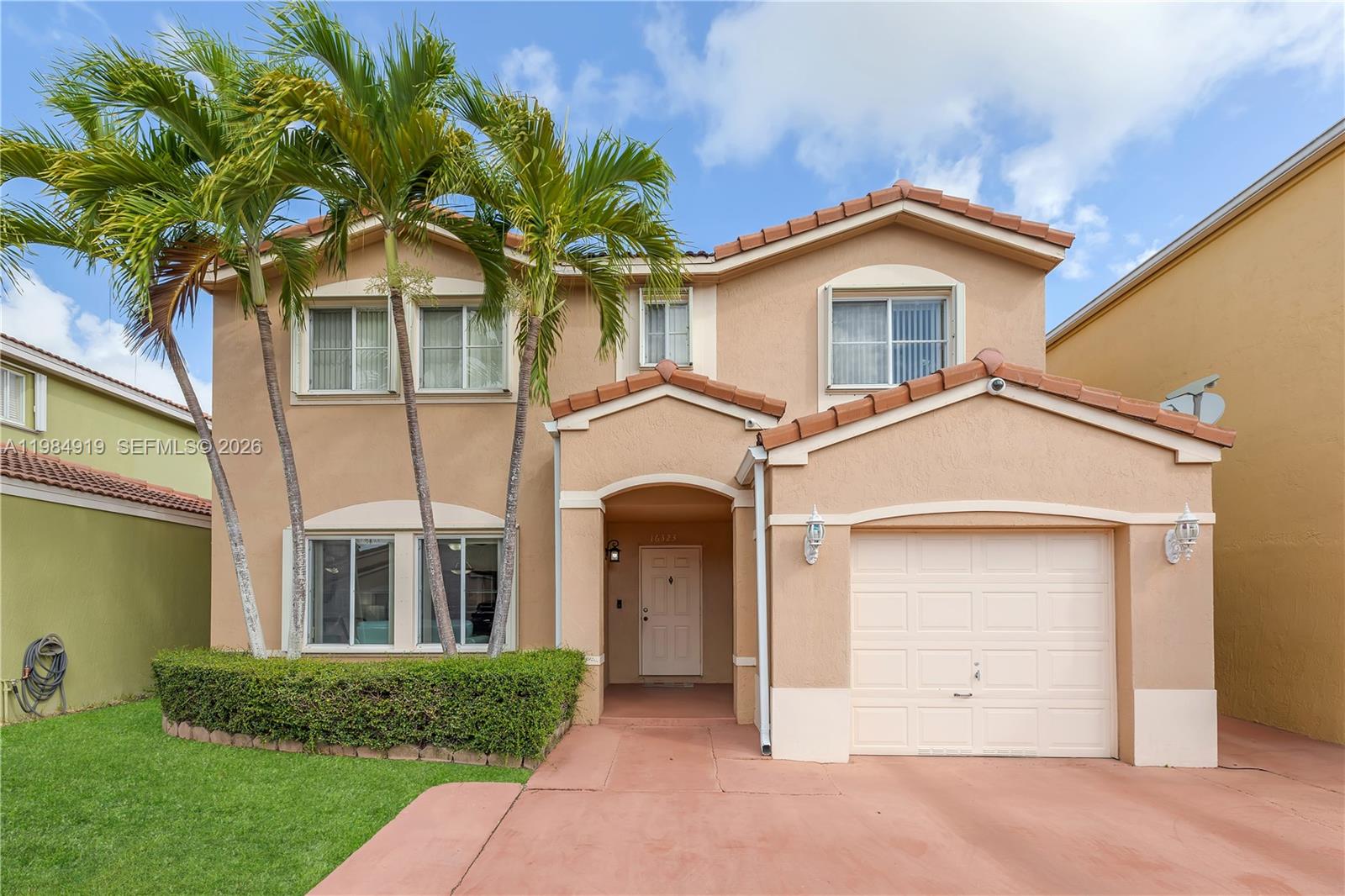 a front view of a house with a garden and plants