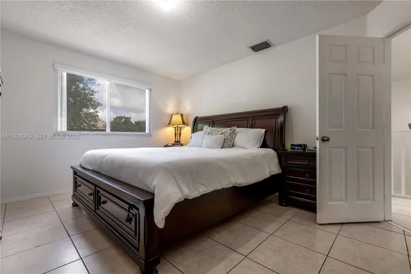 a bed sitting in a bedroom next to a window