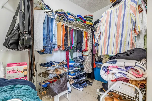 a view of walk in closet with clothes and shoes