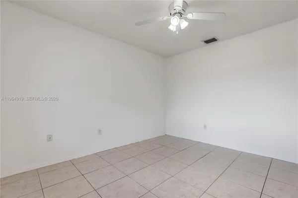an empty room with a chandelier fan